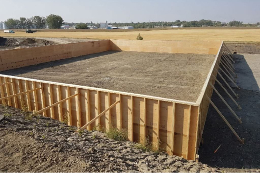 Construction concrete form for a foundation (large) for a garage, on edge of field